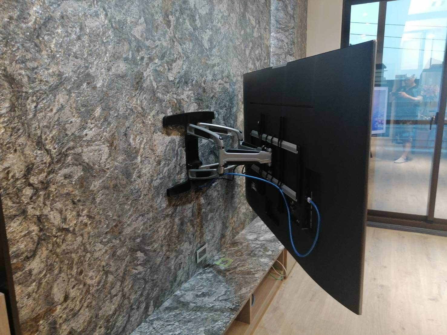 花崗石電視牆安裝旋臂式壁掛架，電視拉出側轉